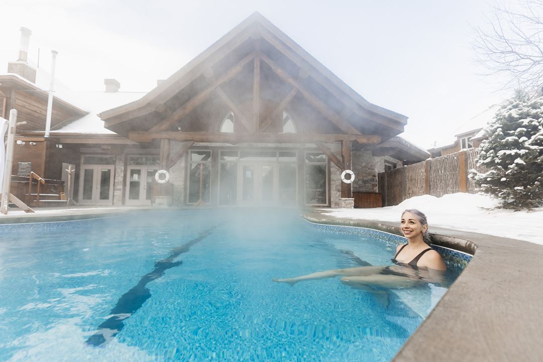 Femme dans la piscine extérieure de l'Auberge du Lac Taureau